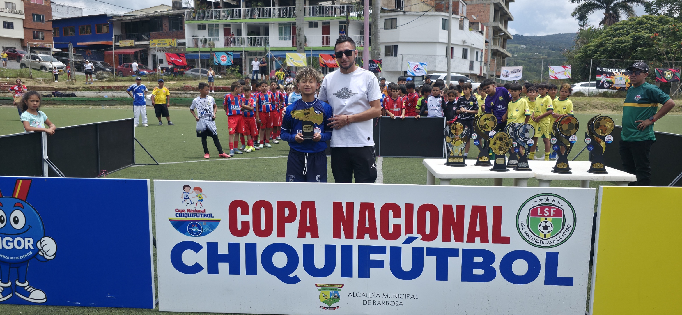 El concejal del deporte de Barbosa, Cristhian Ariza engregando el trofeo al goleador de la final departamental, Andrés Felipe Álvarez,de Supercampeones: hizo 10 goles.